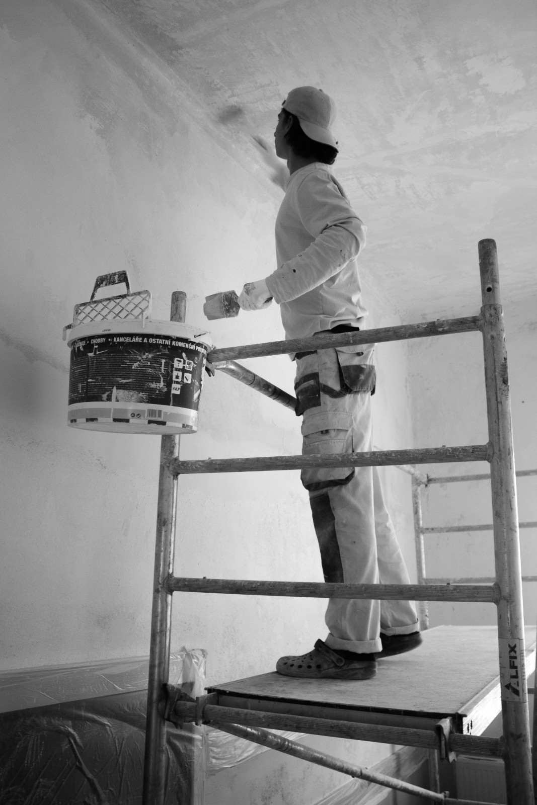 a man painting a wall with a paint roller